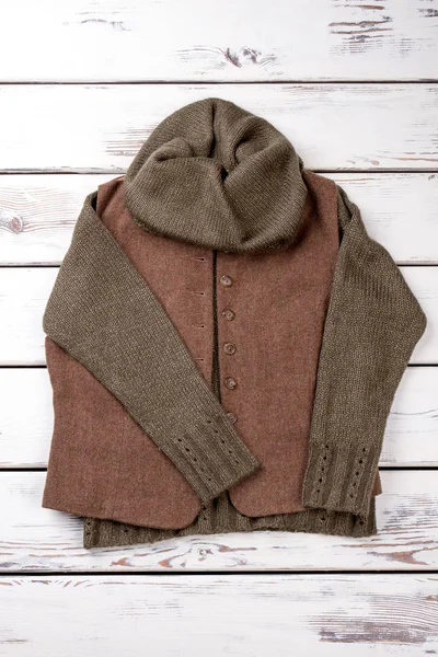 Düz için soğuk kış giyim sıcak yatıyordu. Parlak ahşap arka plan. Dikey görünüm.