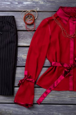 Düz kırmızı ve siyah kadın giyim, atış yatıyordu.