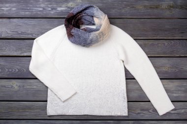 Düz yatıyordu beyaz kazak ve eşarp.