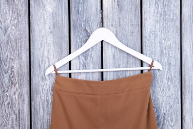 Kahverengi kumaş asılı ile beyaz askı.