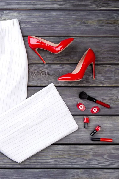 Bir çift kırmızı yüksek topuk ayakkabı ve beyaz pantolon.