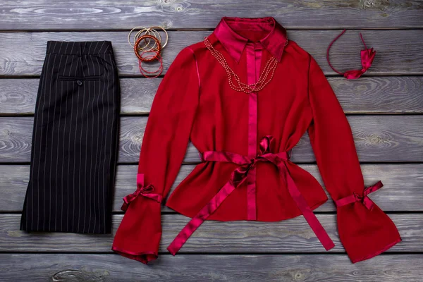 Black trousers and red blouse, flat lay.