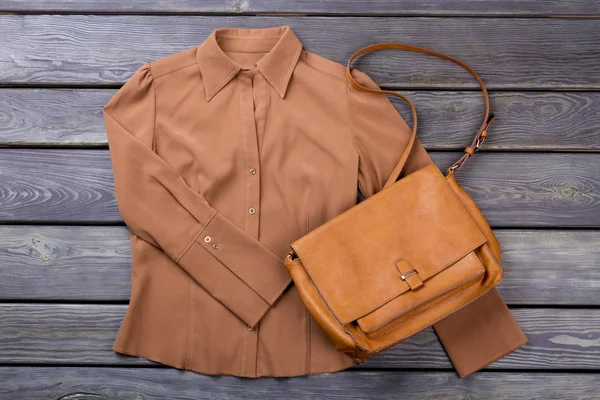 Kahverengi gömlek ve çanta. Düz yatıyordu, en iyi görünüm. Gri ahşap yüzey arka plan.