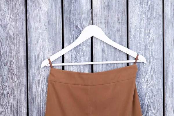 Kahverengi kumaş asılı ile beyaz askı.