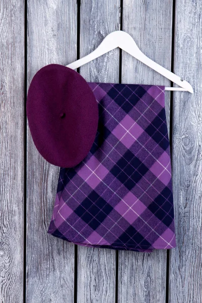 Mor etek ve bere şapka, düz yatıyordu.