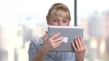 Mutlu kadın kıdemli ofis tablet ile.