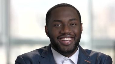 Genç siyah işadamı gülüyor.