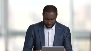 Tablet üzerinde oyun takım elbiseyle siyah adam.