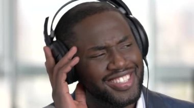 Zenci elbiseli kulaklık ile müzik dinlemek.