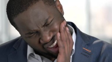 Diş ağrısı olan siyah adam. Portre kadar kapatın. Parlak bulanık windows arka plan.