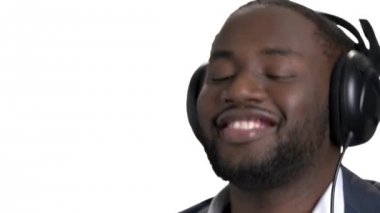 Siyah genç adam kulaklık ile gülümseyen yüzü yukarı kapatın.