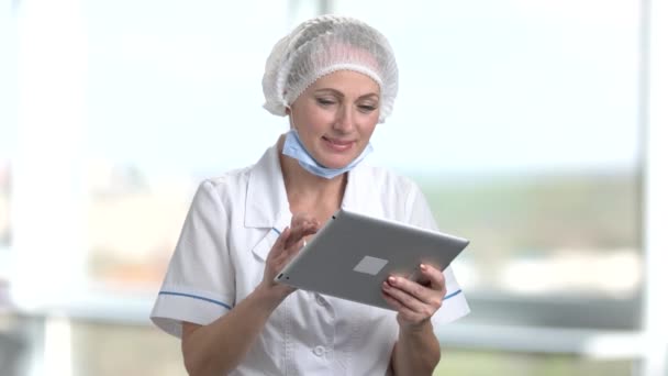 Portret van volwassen vrouwelijke arts met behulp van digitale tablet. — Stockvideo