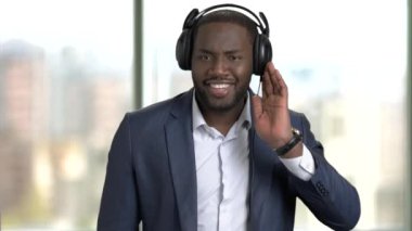 Siyah adam takım ve kulaklık, müzik keyfi.