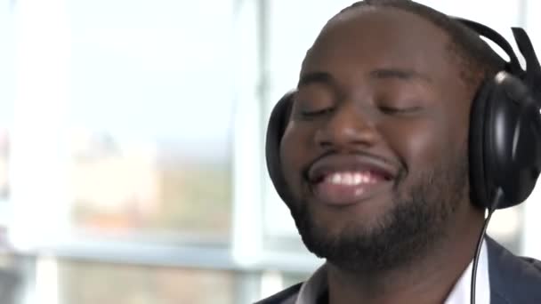 ヘッドフォンで幸せなアフリカ人の顔をアップします。. — ストック動画