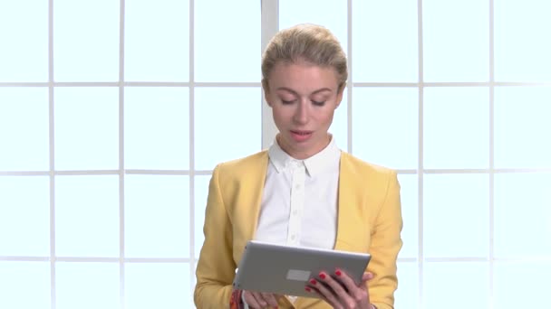 Zakenvrouw in gele jas met tablet. — Stockvideo