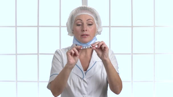 Middle aged female doctor or nurse prescribing medicine. — Stock Video
