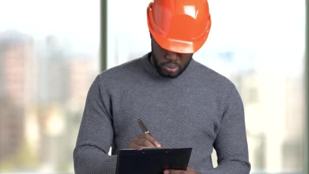 Arquitecto afroamericano escribiendo notas en portapapeles . — Vídeo de stock