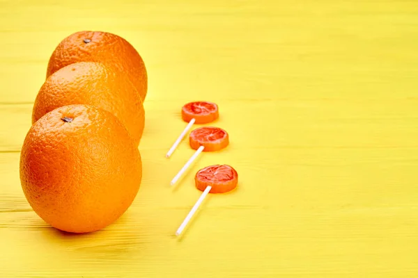 Oranges juteuses fraîches et bonbons sur table en bois . — Photo