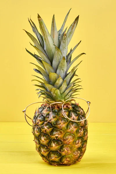 Pineapple in glasses on yellow background. — Stock Photo, Image