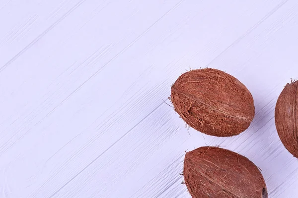 Noix de coco fraîches sur table en bois blanc . — Photo