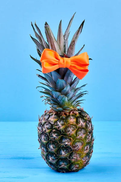 Composition from pineapple on blue background.