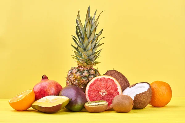Σύνθεση από τροπικά φρούτα σε κίτρινο φόντο. — Φωτογραφία Αρχείου