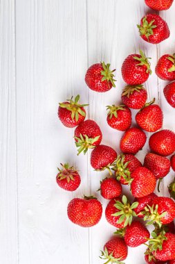 Olgun organik çilek, üstten görünüm. Beyaz tahta ve metin için yer taze çilek sınırdan yan.