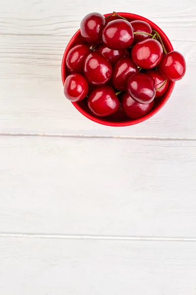 Cerejas frescas em panela vermelha, vista superior . — Fotografia de Stock