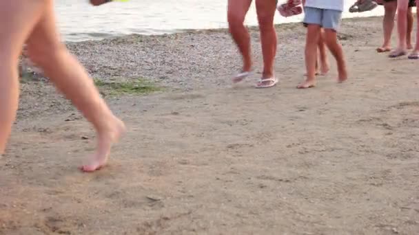 Mensen lopen langs de kust. — Stockvideo