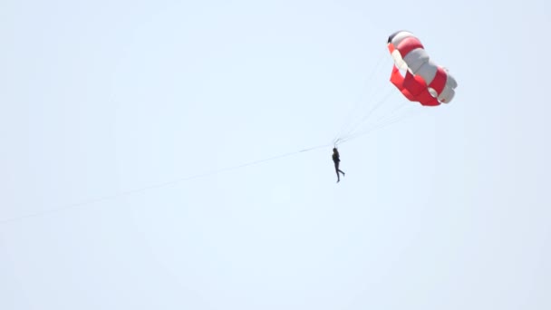 Человек с парашютом на фоне неба . — стоковое видео