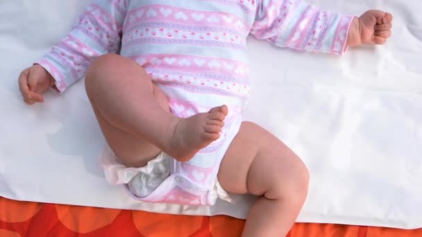 Младенец в костюме лежит на спине . — стоковое видео