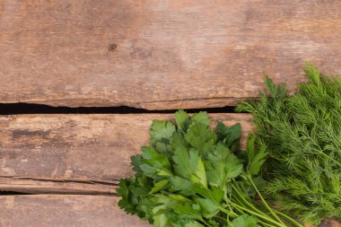 Ahşap masa üzerinde Bahçe taze dereotu ve maydanoz otlar.