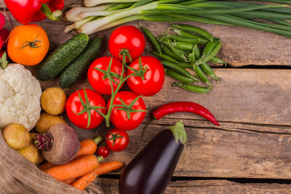 Variety of different fresh vegetables on wood.