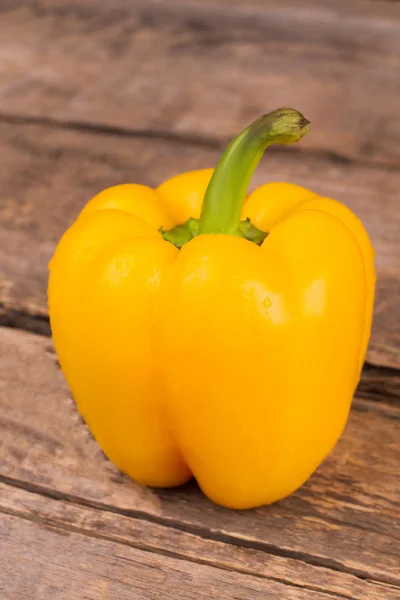 Amarelo fresco uma pimenta no fundo de madeira rústico . — Fotografia de Stock