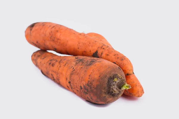 Stapel von rohen, orangen, schmutzigen Karotten. weißer isolierter Hintergrund, Ausschnitt. — Stockfoto