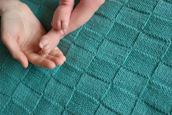 Ноги новорожденного и рука взрослого . — стоковое фото