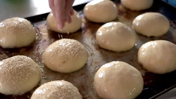 Spargimento a mano di semi di sesamo su pasta . — Video Stock