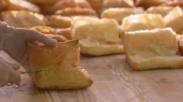 Baker in handschoenen snijden gebakken gebak. — Stockvideo