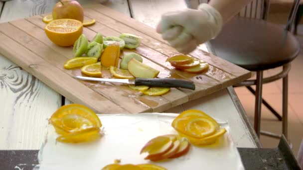 Повар вручную обрабатывает ломтики яблок с лимонным соком. — стоковое видео