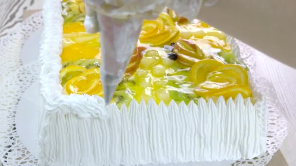 Украшение торта белыми взбитыми сливками . — стоковое видео