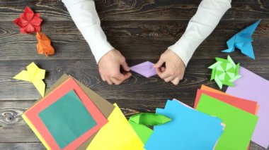 Adam ellerini mor kağıt origami yapmak.