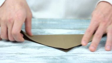 Erkek el ile kahverengi kağıt origami oluşturma.