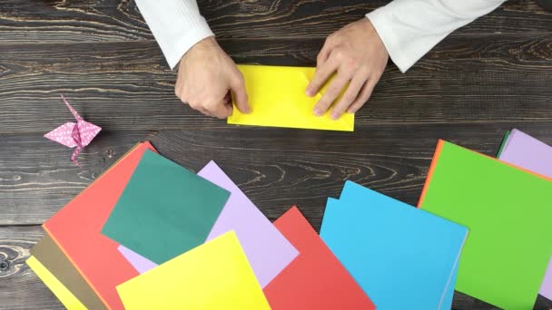 Manos masculinas haciendo origami con papel amarillo . — Vídeo de stock