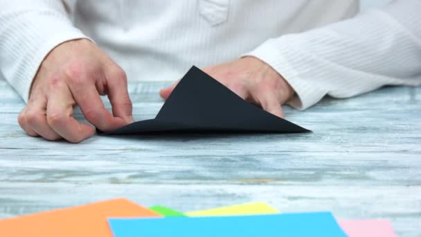 Manos masculinas creando figura de origami . — Vídeos de Stock
