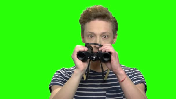 Excited curious teenage boy looking through binoculars. — Stock Video