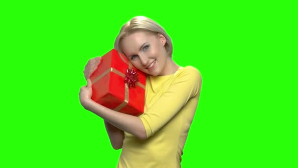 Imádnivaló kaukázusi nő átölelve piros ajándék doboz.