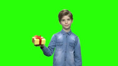 Sevimli küçük çocuk sarı hediye kutu kırmızı kurdele ile işaret.