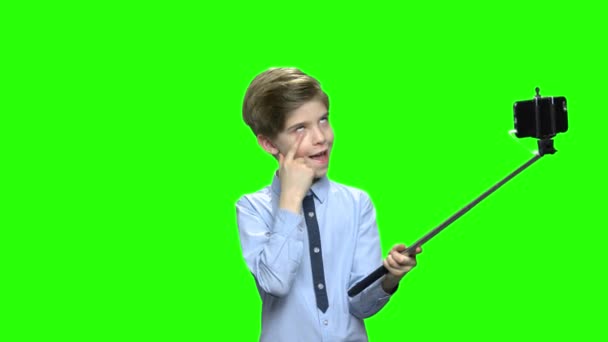 Cute boy making funny face and holding selfie stick. — Stock Video