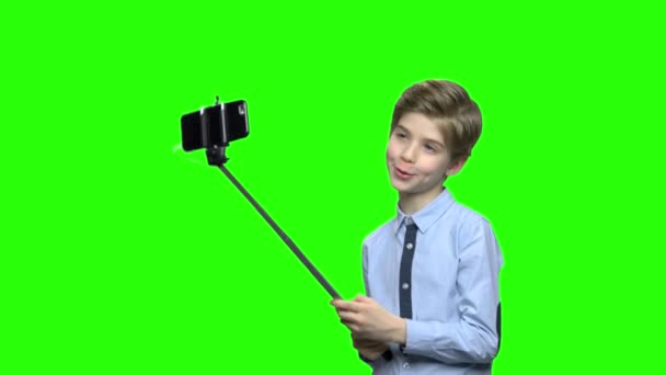Leuke blanke jongen met selfie stick poseren voor de camera. — Stockvideo