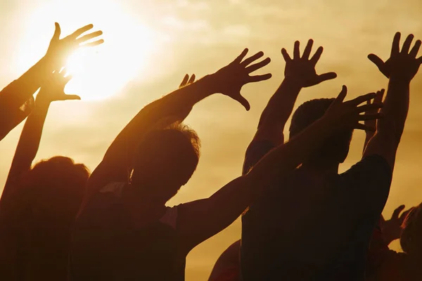 Pessoas tocando o brilho dourado do sol . — Fotografia de Stock